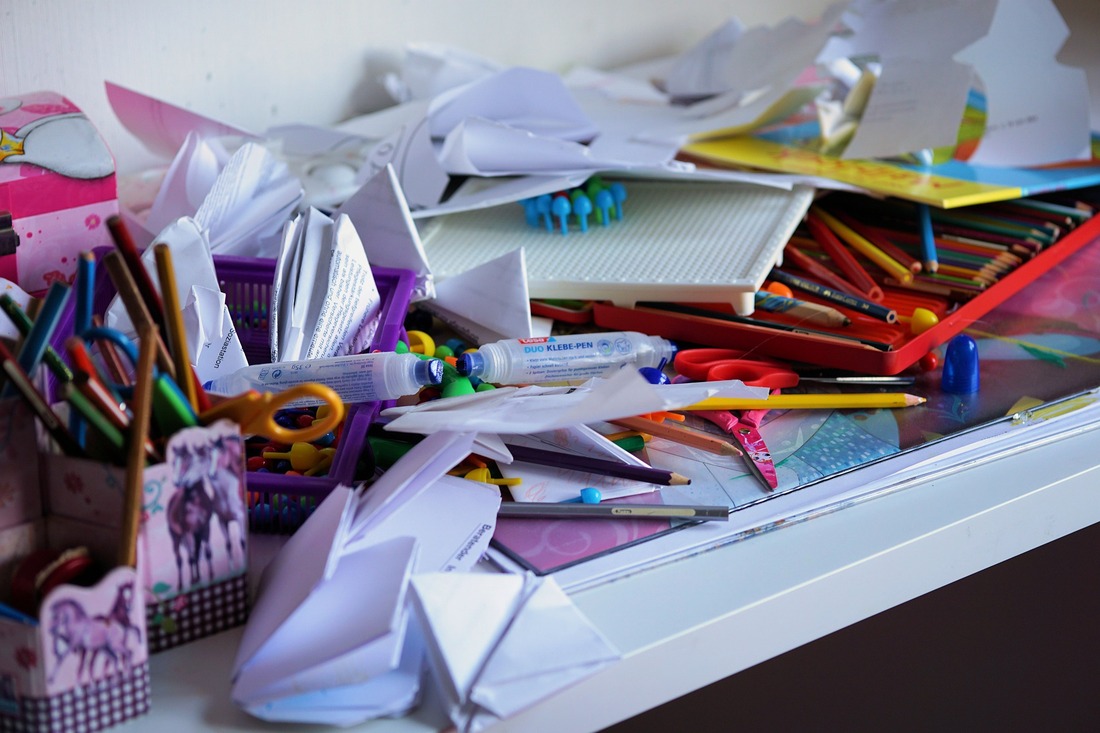 This messy desktop covered in paper, pencils, and other supplies is an example of a space where staying organized isn't helping.