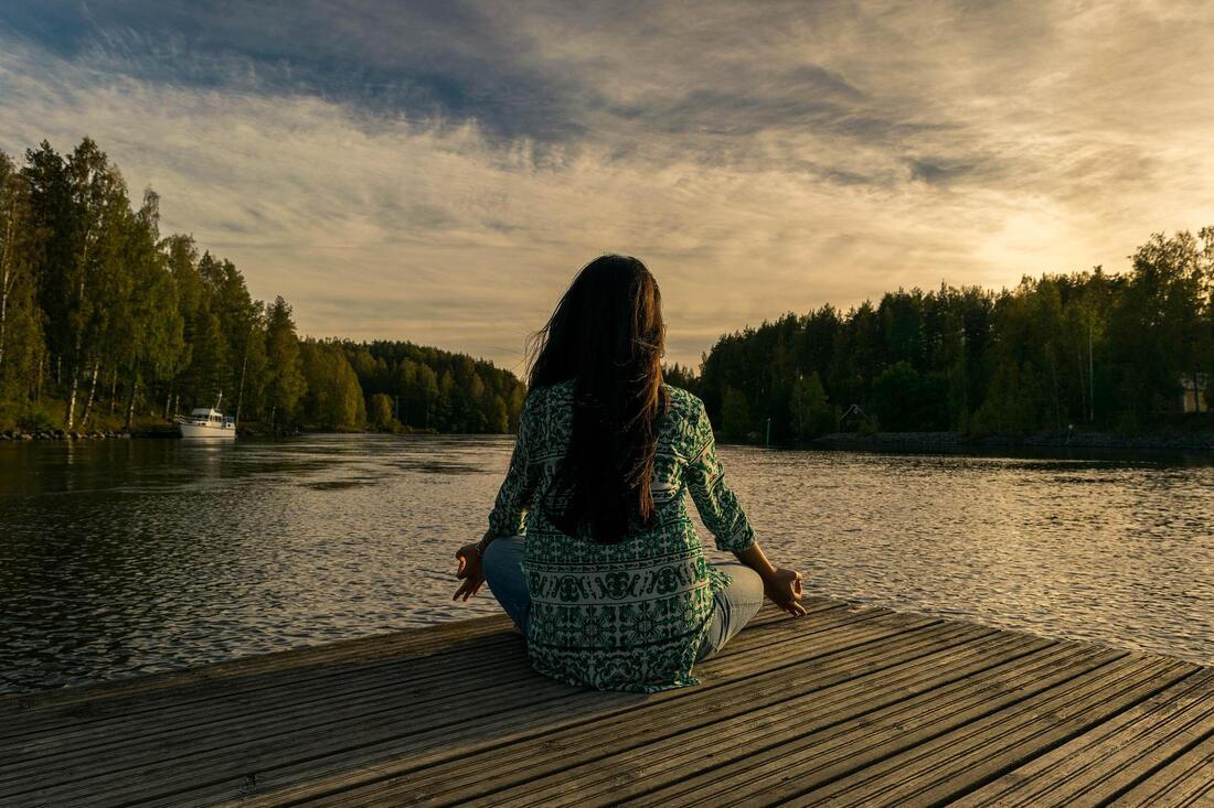 You can sit in your home or even, like this woman, at a lake, to do a home decluttering meditation. 